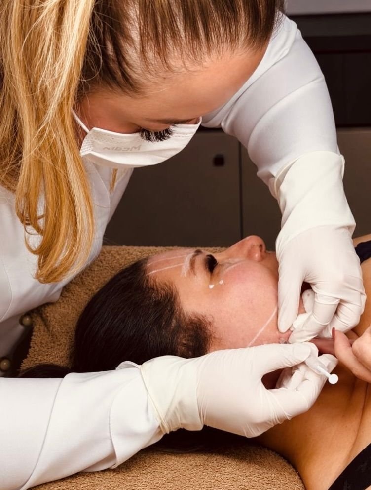 Aplicação de toxina botulínica com luvas, em paciente deitada, para tratamento terapêutico
